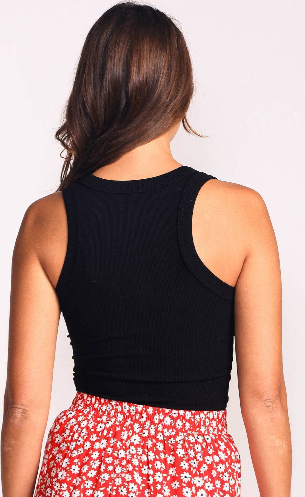 Back view of woman wearing black Danika top with red floral skirt