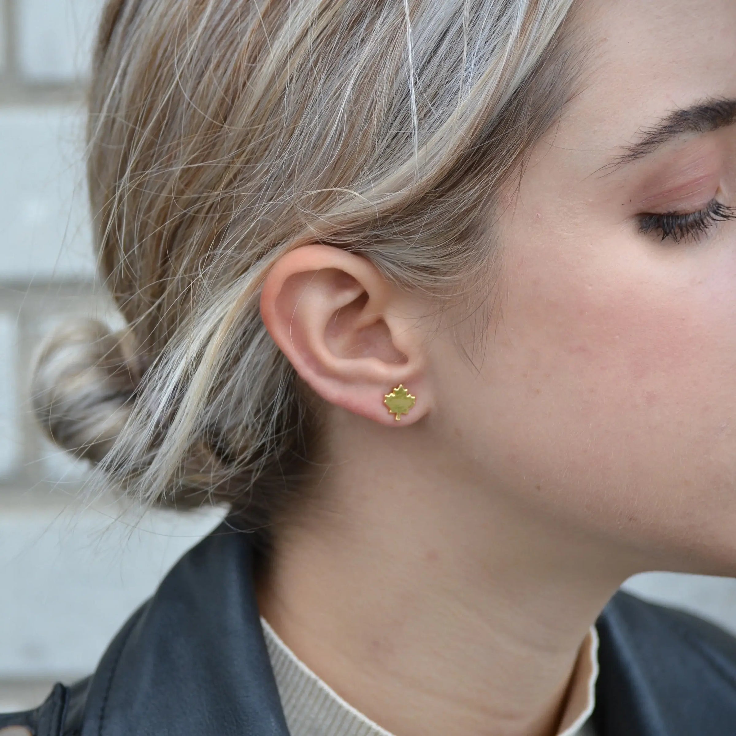 Side view of Foxy Originals Maple Leaf stud earrings in gold, worn outdoors — photographed near Lemonberry in Aurora, ON