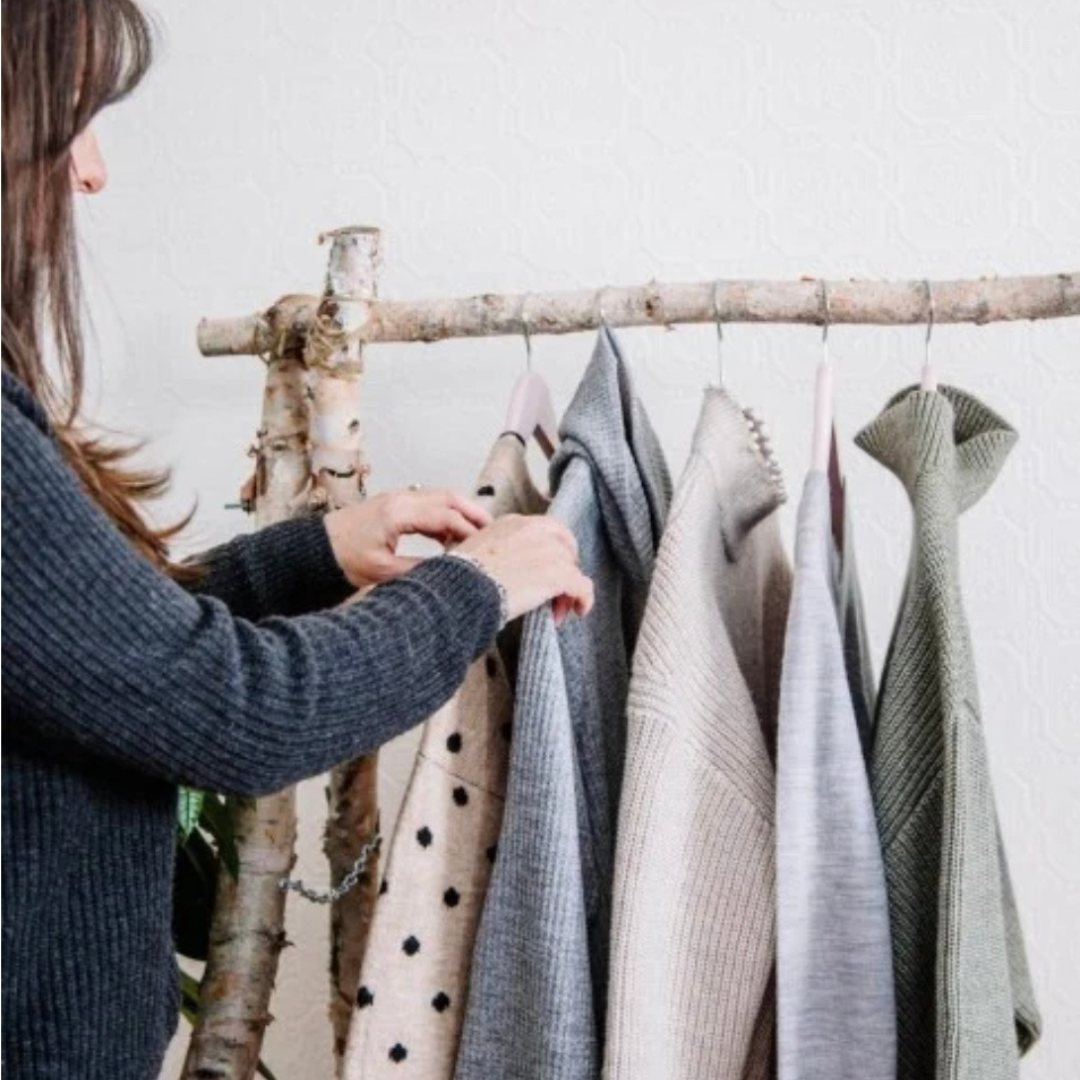 Woman browsing her capsule wardrobe in a cozy, minimalist closet – Lemonberry sustainable fashion, Aurora ON
