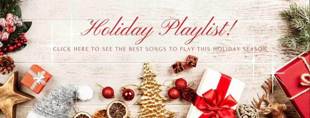 Holiday Playlist with Christmas gifts, gold ornaments, and festive decorations on white wood background