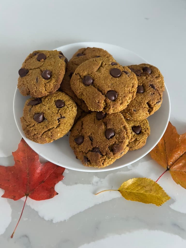 Pumpkin spice chocolate chip easy to make cookies on a plate with leaves around it