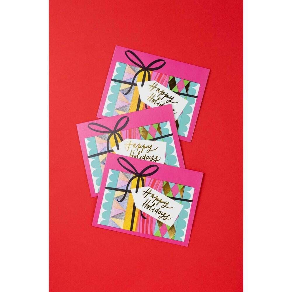 Three colorful greeting cards with 'Happy Holidays' text on a red background