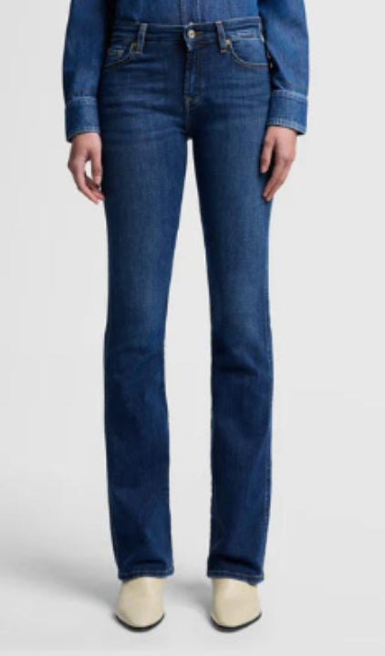 Person wearing blue jeans on a light gray background