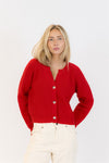 Woman wearing a red cardigan on a white background