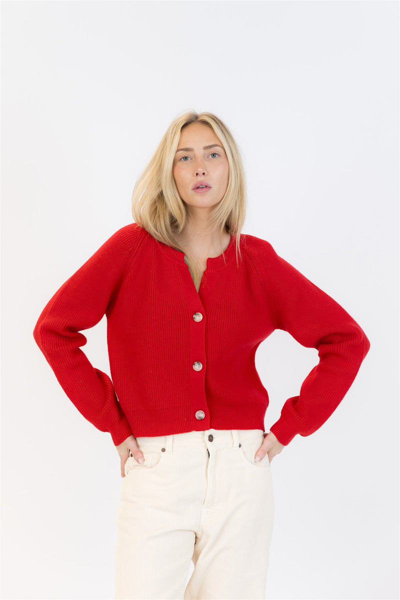 Woman wearing a red cardigan on a white background