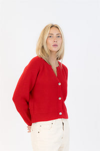 Woman wearing a red cardigan on a white background