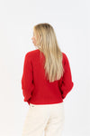 Person wearing a red sweater on a white background