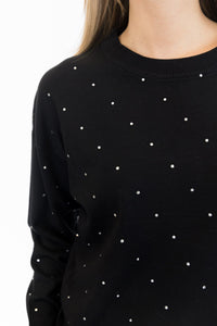 Black sweater with white polka dots on a white background