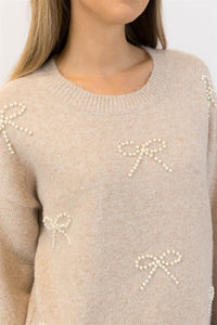 Detailed close-up of neckline and pearl bow detailing