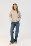 Model wearing Lyla & Luxe BOWS-F25 eco crewneck sweater with pearl bows in beige, standing studio view – Lemonberry