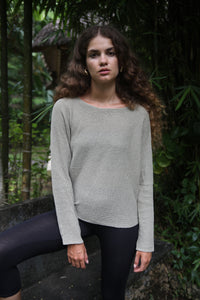 Front view of the Beach Comber relaxed boatneck sweater in linen with black leggings – A relaxed fit boatneck sweater made from linen and organic cotton, paired with black leggings. Available at Lemonberry, Aurora, ON.