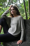 Side view of the Beach Comber relaxed boatneck sweater in linen with black leggings – Soft linen and organic cotton sweater, showing the side fit with black leggings. Available at Lemonberry, Aurora, ON.