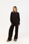 Lyla & Luxe Claret crewneck pullover in chocolate brown, styled with matching wide-leg pants