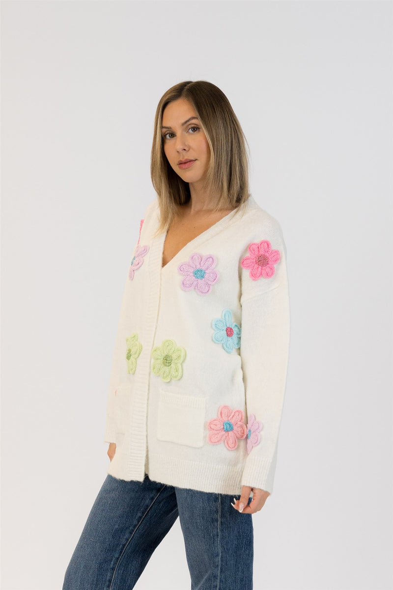 Angled view of model in Lyla & Luxe Elska cardigan, highlighting the playful flower placement across the chest and sleeves.
