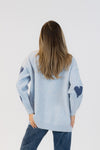 Back view of the Elska Heart cardigan showing scattered heart pattern on sleeves