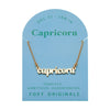 Foxy Originals Capricorn Zodiac Necklace on its display card, featuring a gold script-style pendant with stylish packaging.