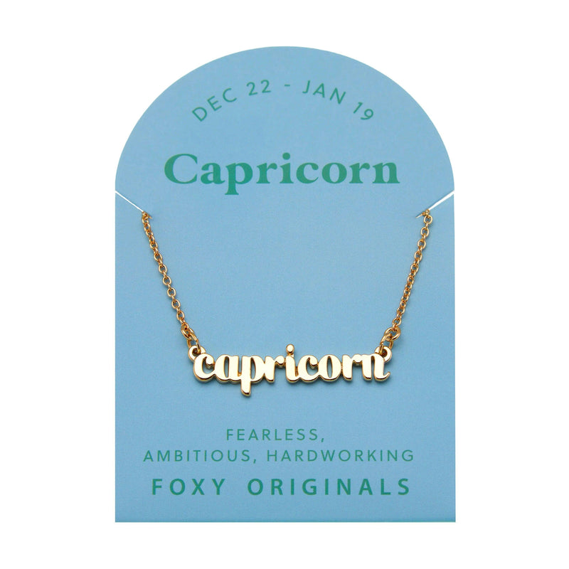 Foxy Originals Capricorn Zodiac Necklace on its display card, featuring a gold script-style pendant with stylish packaging.