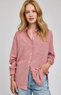 Woman wearing a rGarnet striped button-down shirt by Gentle Fawn with blue jeans on a gray background