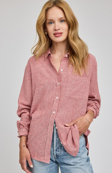 Woman wearing a rGarnet striped button-down shirt by Gentle Fawn with blue jeans on a gray background