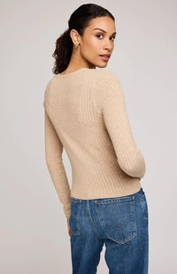 Back view of the Mia V-Neck Pullover by Gentle Fawn paired with denim, showing full cable knit and stitch pattern on the back.