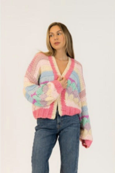 Model wearing candy-coloured pastel cardigan with open front and blue jeans