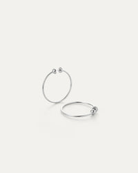 Pair of Jenny Bird Icon Hoops Small in silver shown flat on a neutral background