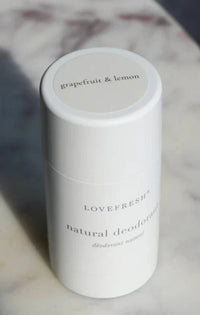 A close-up of Lovefresh Grapefruit & Lemon Natural Deodorant in regular strength, showcasing its smooth texture and bright, citrus-themed packaging.