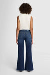 Model wearing 7 For All Mankind Lotta High-Waist Flare Jeans in Dark Blue, back view.