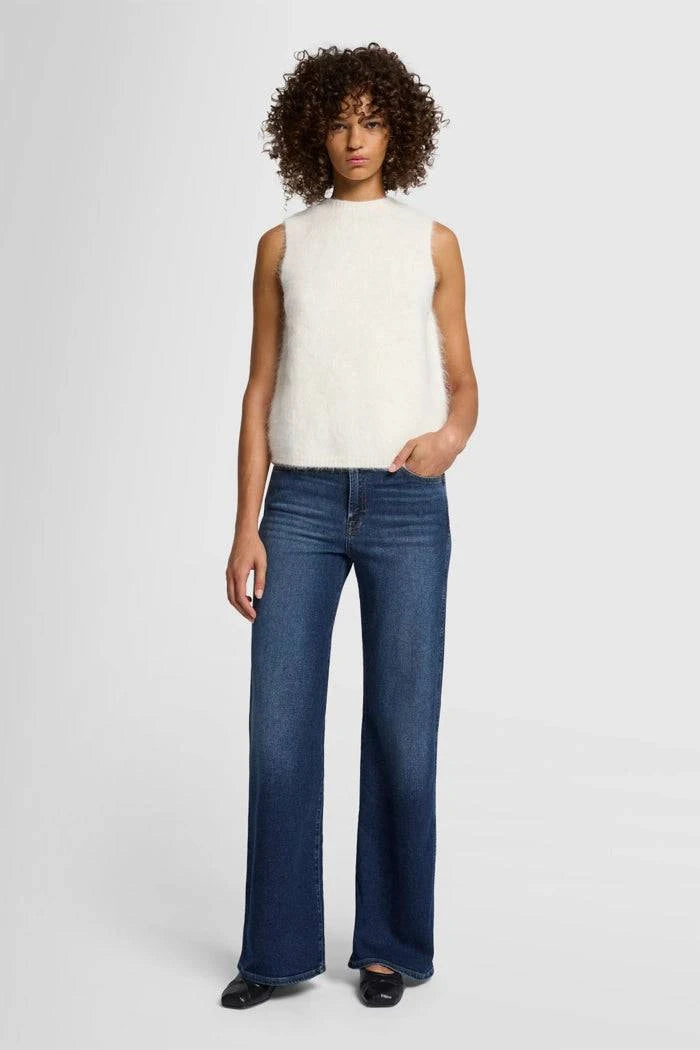 Model wearing 7 For All Mankind Lotta High-Waist Flare Jeans in Dark Blue, front view.