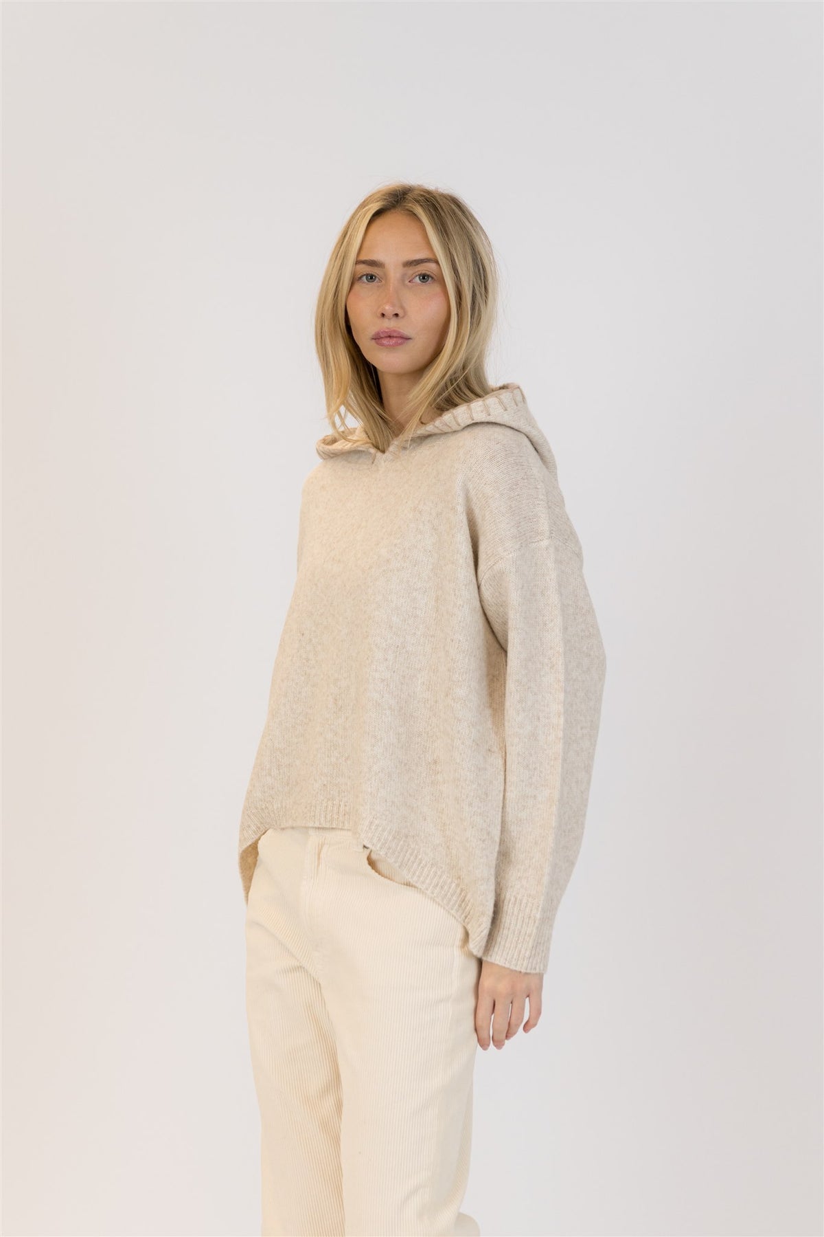 Side profile of beige knit hoodie sweater with relaxed fit