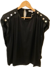 Black top with white buttons on a wooden hanger