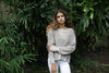 A linen-colored waffle-knit sweater paired with white leggings, featuring a lightweight, breathable texture. Available at Lemonberry, Aurora, ON.