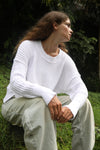 Model sitting down in a white waffle-knit sweater and baggy pants, highlighting the softness and comfortable fit. Available at Lemonberry, Aurora, ON.