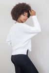 Side view of a white waffle-knit sweater with black leggings, highlighting the drape and cozy fit. Available at Lemonberry, Aurora, ON.