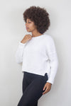 Side view of a white waffle-knit sweater with black leggings. Available at Lemonberry, Aurora, ON.