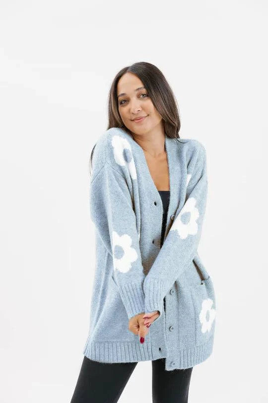 Smash and Tess Flora Cardigan in blue and white, featuring a floral design, patch pockets, long bum-covering length, and relaxed fit made from soft feathery yarn.