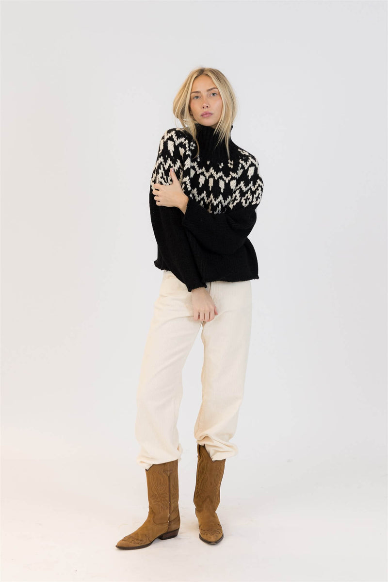 Full outfit featuring Lyla & Luxe Fair Isle sweater in black and white paired with cream cord pants.