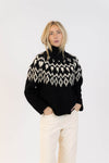 Lyla & Luxe Aggie turtleneck sweater styled with cream pants and hands in pockets for a relaxed winter look.