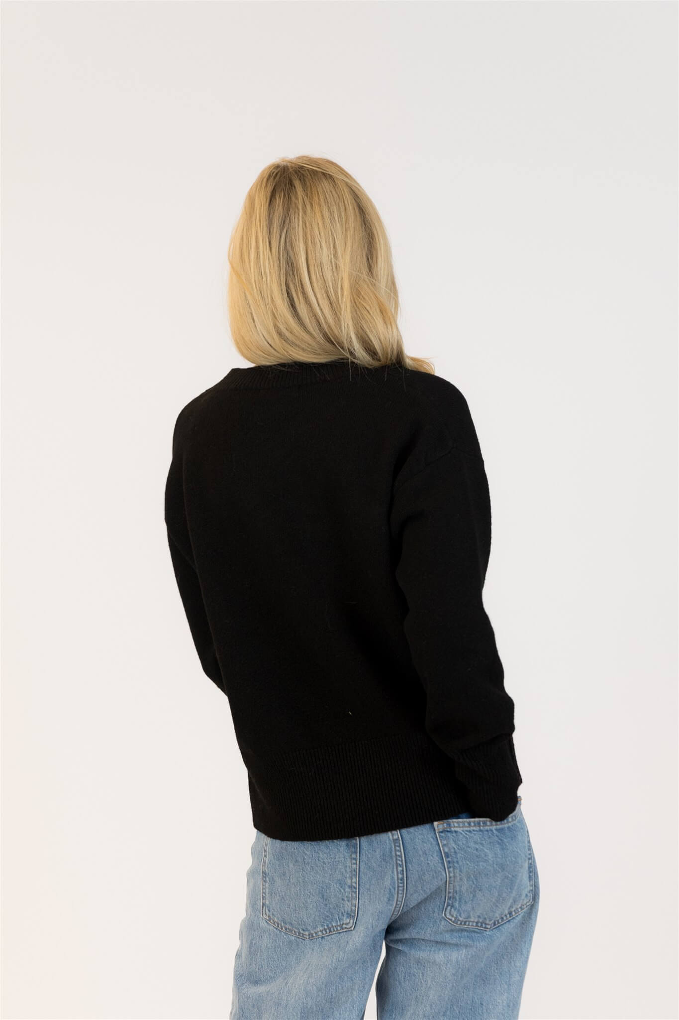 Back view of Lyla & Luxe Ajax Sherpa Sweater in black knit with plain back and ribbed hem