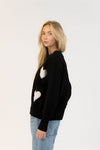 Side angle of Lyla & Luxe Ajax Sherpa Sweater featuring oversized hearts and relaxed fit