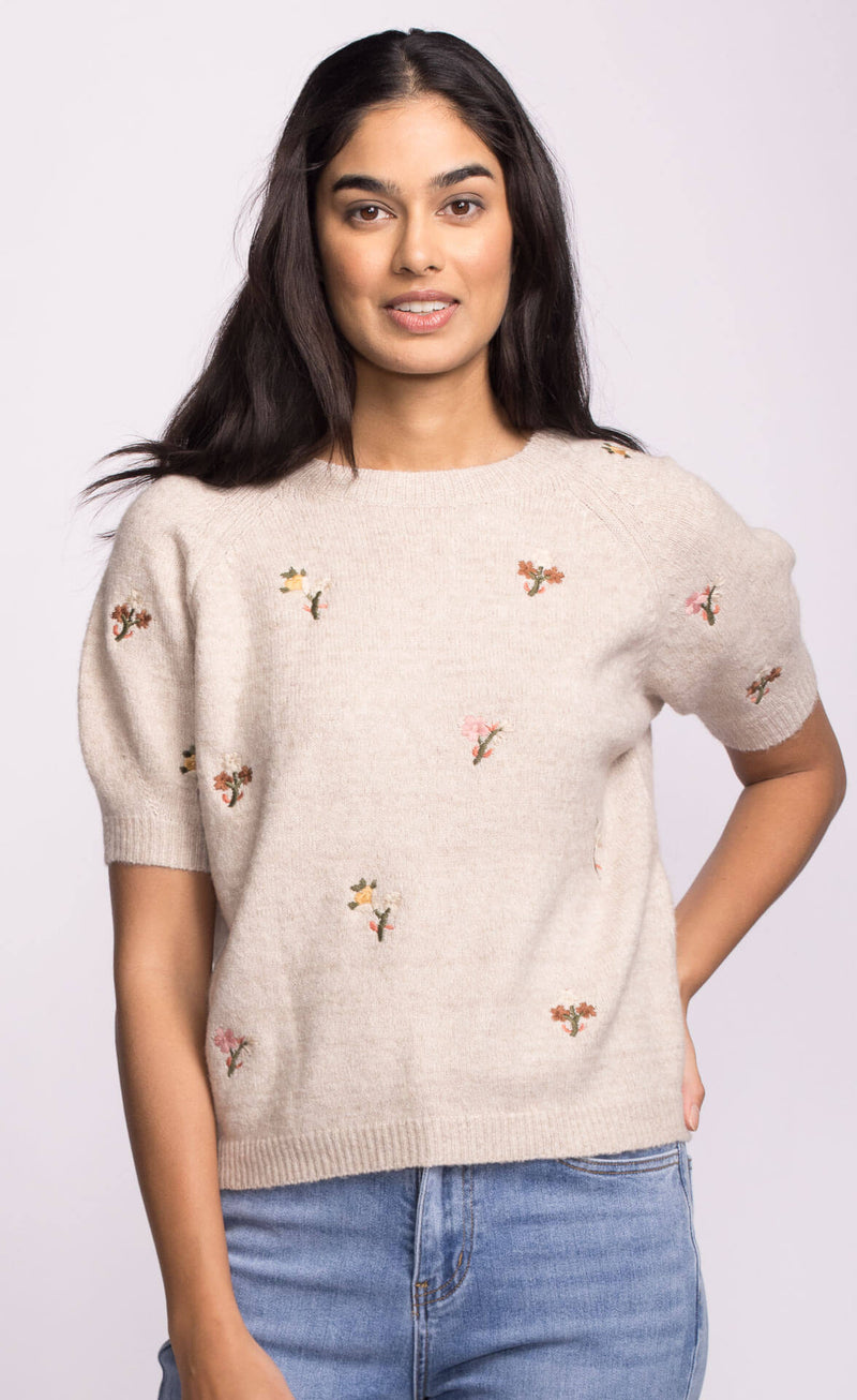 Model wearing the Alva Sweater by Pink Martini, beige knit with delicate floral embroidery on the front.