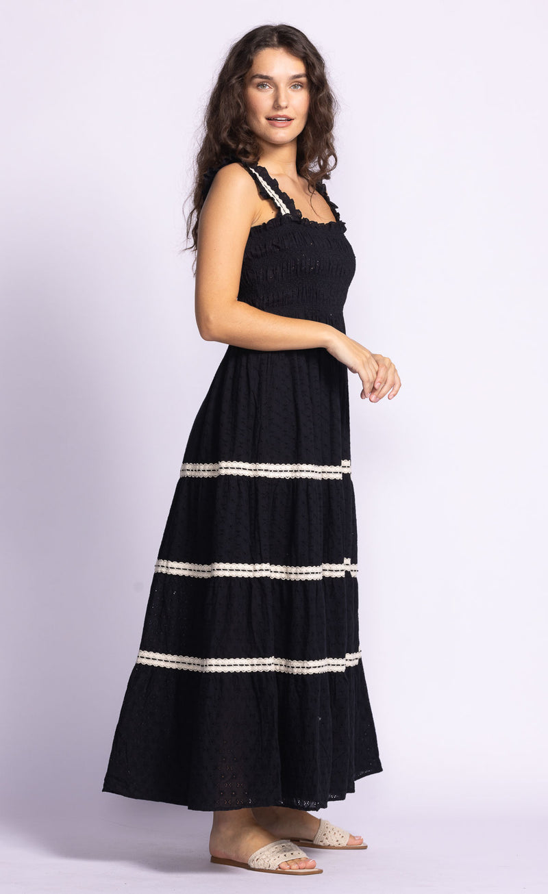 Side view of the Amber Dress by Pink Martini, featuring ruffle embroidered straps and a flowing midi length.