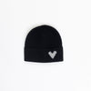 Black beanie with a white heart pattern on a light gray background