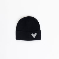 Black beanie with a white heart pattern on a light gray background
