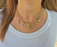 Gold Bella Charm Necklace with five charms styled on model in ribbed white top – Foxy Originals at Lemonberry