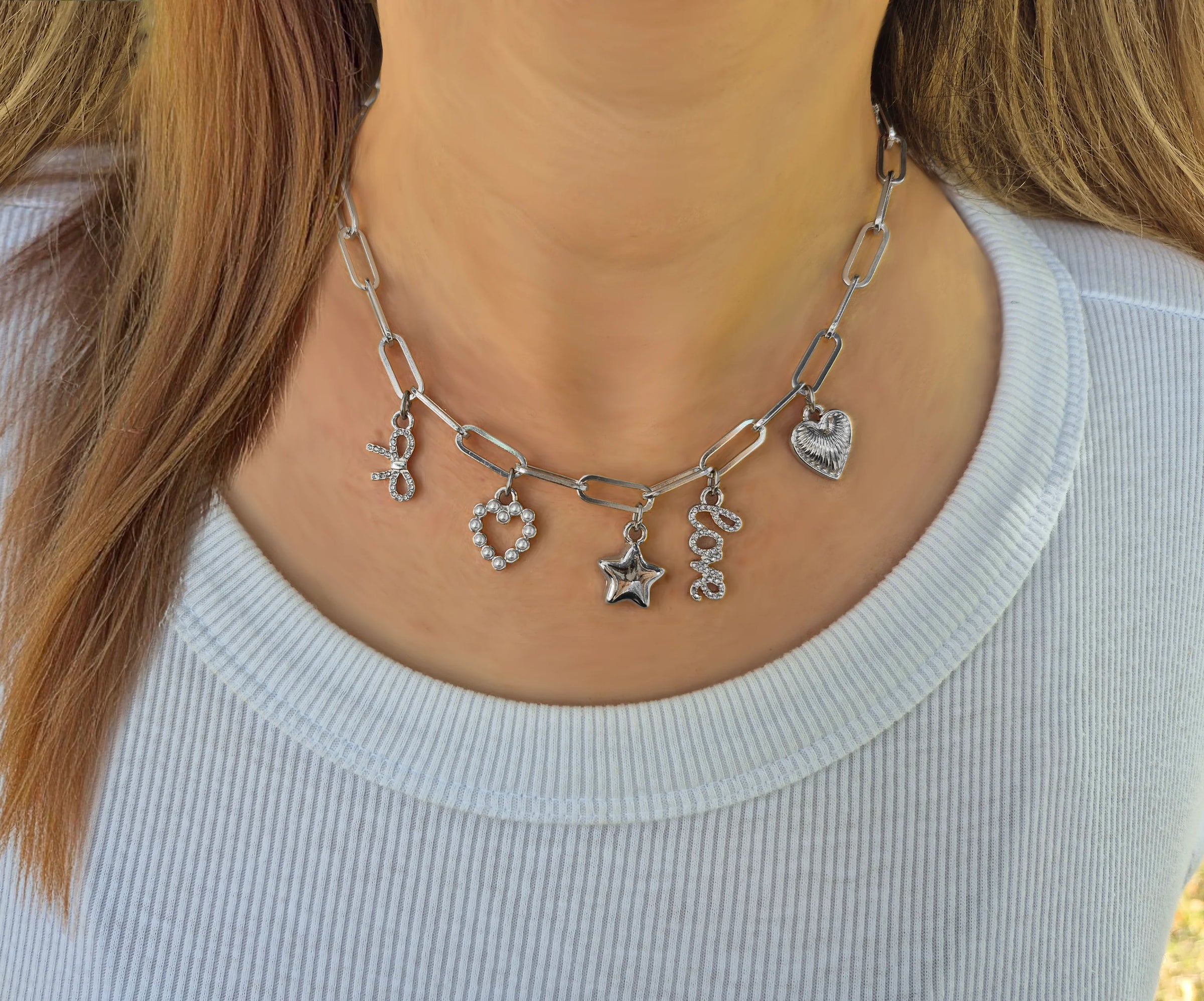 Silver Bella Charm Necklace with heart, star, bow, “love,” and pearl heart charms – Foxy Originals styled on model in white top