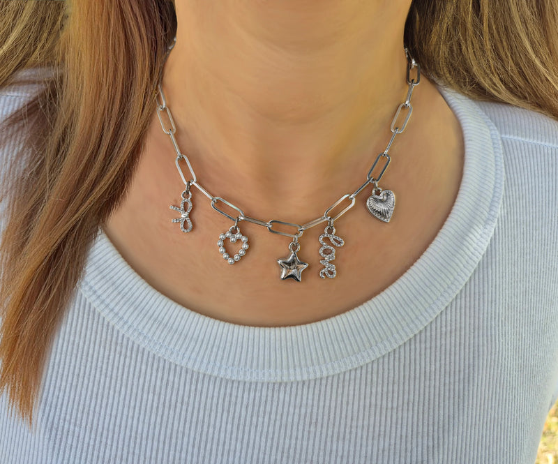 Silver Bella Charm Necklace with heart, star, bow, “love,” and pearl heart charms – Foxy Originals styled on model in white top