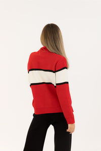 Red sweater with black and white stripes worn by a person on a white background