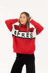 Woman wearing a red sweater with 'APRES' text on a white background