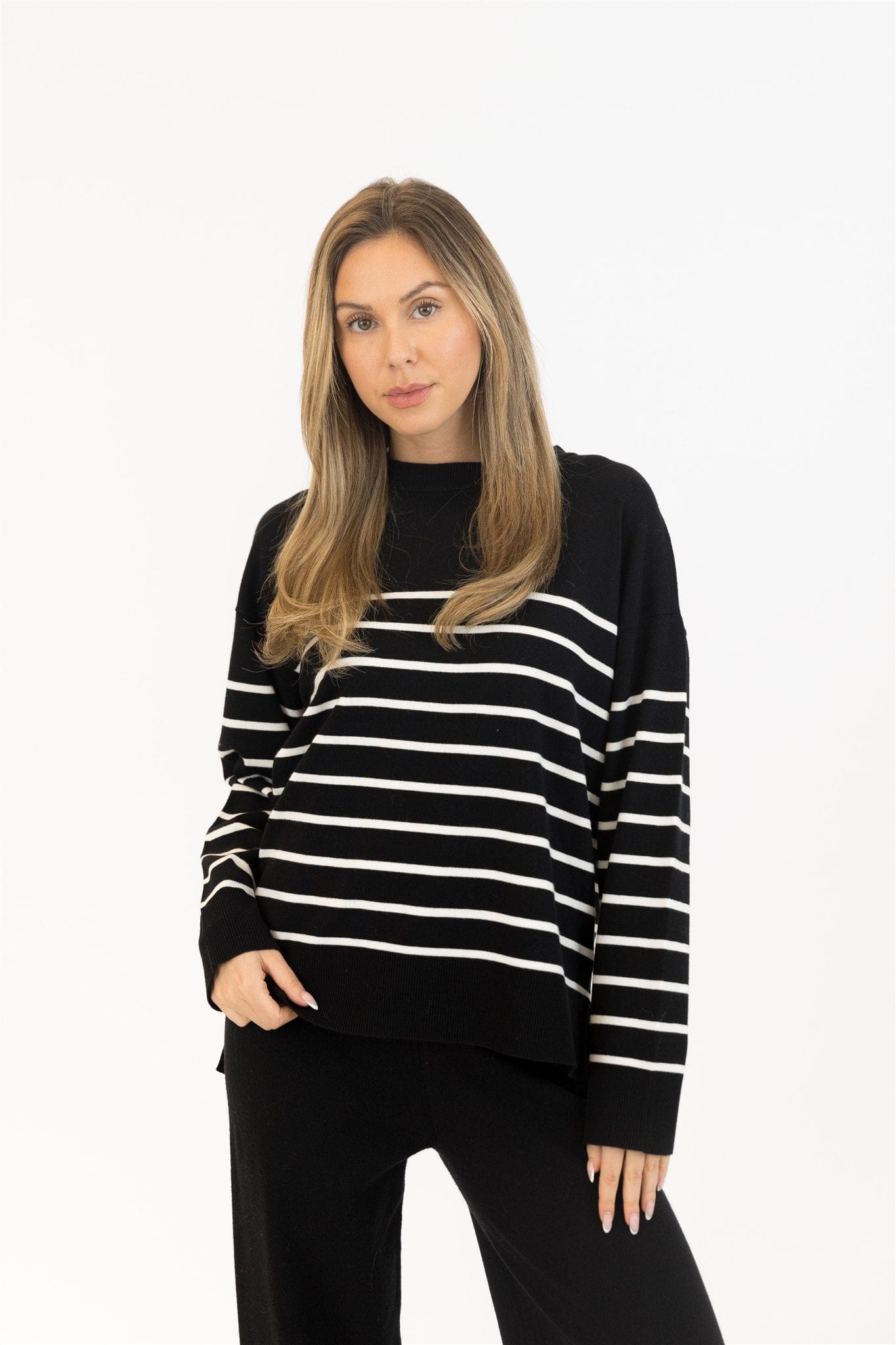 Woman wearing a black and white striped sweater on a white background